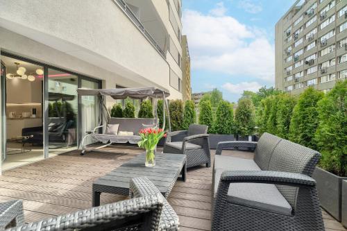 斯维诺乌伊希切Apartments Ostsee Suntowers的庭院配有椅子和鲜花桌子。