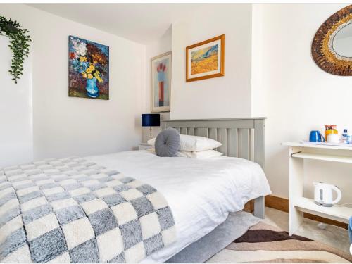 牛津Charming Doubleroom in North Oxford Minimum 3 nights的卧室配有一张带格子毯子的白色床