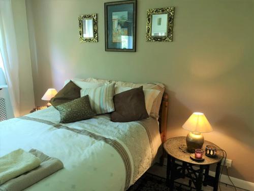 伦敦2 Dbl Bed Top Floor Modern Oriental Flat Greenwich Park的一间卧室配有一张床和一张带台灯的桌子