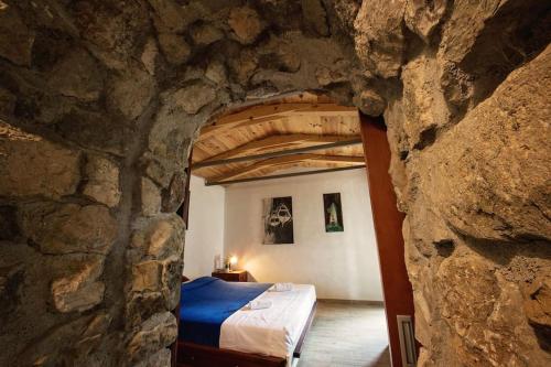 布雷拉Holiday home Raos - a special stonehouse, Brela的一间位于石墙的卧室,卧室内配有一张床
