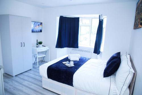 伦敦Lovely Apartment with free parking on premises.的一间卧室配有一张带蓝色毯子的床和窗户。