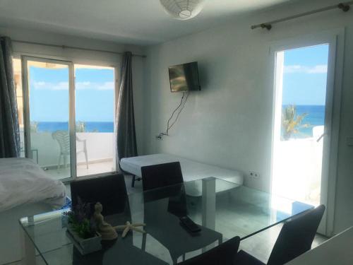 普拉亚登博萨Thee Ibiza Suites - Ushuaia Beach的客厅配有书桌,享有海景
