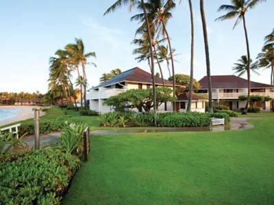 科洛阿Kiahuna Plantation Resort Kauai by OUTRIGGER的棕榈树和绿色庭院的房子