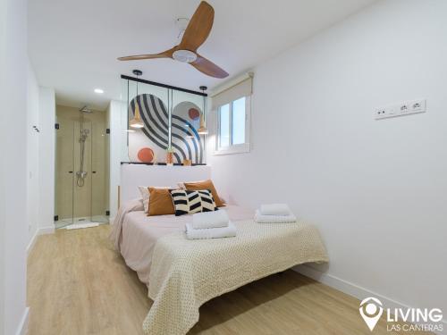 大加那利岛拉斯帕尔马斯Living Las Canteras Homes - BEACHFRONT IN STYLE的一间卧室配有一张床和吊扇