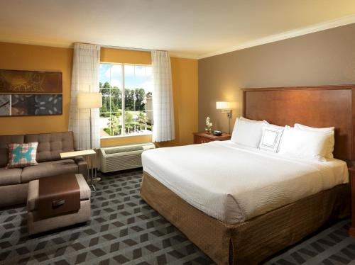 休斯顿休斯顿洲际机场万豪广场套房酒店的酒店客房设有一张大床和一张沙发。