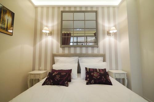 巴黎圣日耳曼优雅奇客修特斯公寓的卧室配有白色的床和2个枕头
