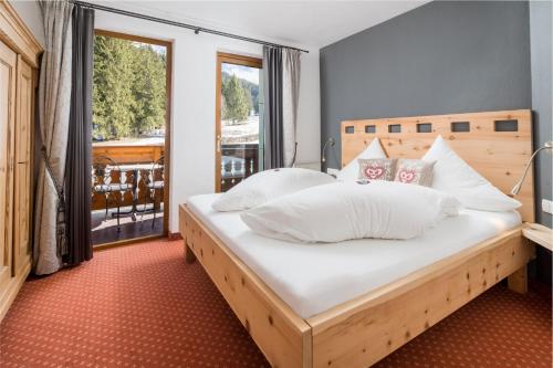 纳瑟尔文勒塔恩赫姆谷桑内施洛斯公寓的卧室配有带白色枕头的大床