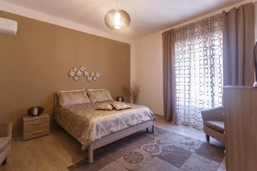 圣安蒂奥科Montellinos Suite Tortora的一间卧室设有一张床和一个大窗户