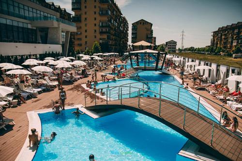 RoşuFun Apartament Militari Residence的一个带人员和遮阳伞的大型游泳池