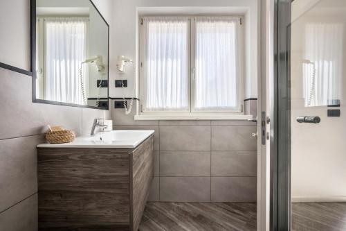 德罗Appartamenti Gaggiolo 1的一间带水槽、镜子和淋浴的浴室
