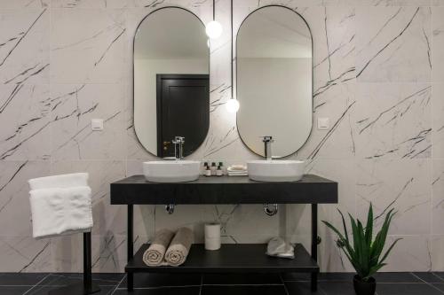 巴尔Soho Suites的浴室设有2个水槽和2面镜子