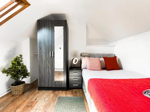 利物浦Laid-back Midtown Retreat的一间卧室配有红色的床和镜子