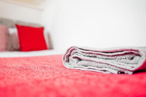 利物浦Laid-back Midtown Retreat的红色床铺上方的白色毛巾
