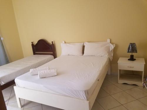 圣菲利佩chez albino guest house的一间卧室配有两张带白色床单和灯的床