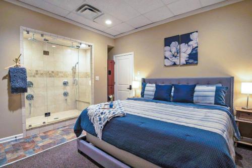 纳什维尔Fire And Rainfall Rooms的一间卧室配有蓝色的床和淋浴