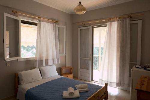 尼基亚娜CHRISTINAS STUDIOS NIKIANA的一间卧室配有一张带两顶帽子的床和两个窗户