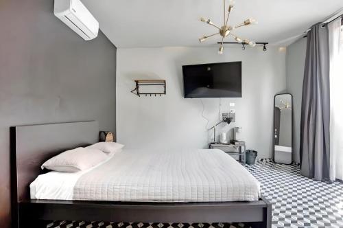 恩塞纳达港The Studios 22800的卧室配有一张床,墙上配有电视。