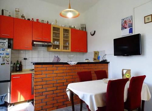 拉斯托伏Studio Apartman Ana的厨房配有红色橱柜和一张带红色椅子的桌子