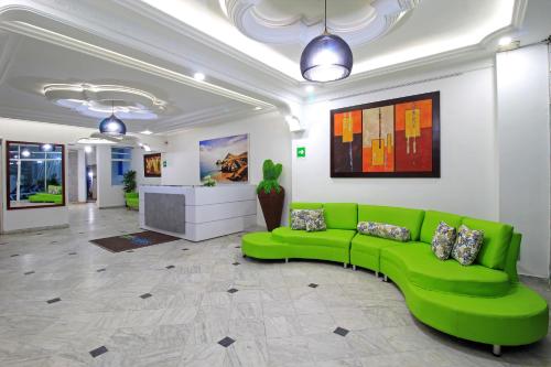 卡塔赫纳Hotel Abi Inn By GEH Suites的绿沙发,位于房间中间