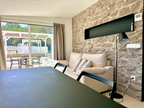 卡拉瓦德亚Cala Vadella Beachwalk Suites的客厅配有桌子和石墙