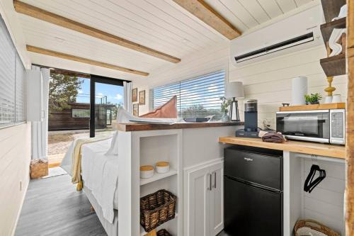 弗雷德里克斯堡New The Sunrise Cozy Container Home的一间小房子里的厨房,配有水槽和微波炉