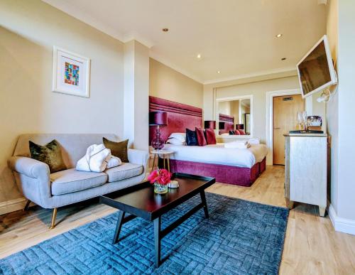 邓巴贝斯韦尔公园酒店 的酒店客房配有床、沙发和桌子。