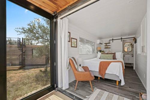 弗雷德里克斯堡New The Saguaro-Tiny Shipping Container Home的一间卧室设有一张床和一个大窗户