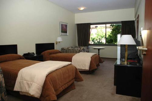 布兰卡港Hotel Austral Bahía Blanca的酒店客房,设有两张床和一张沙发