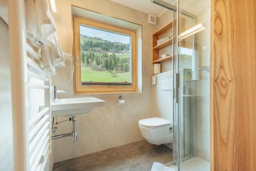 锡利安吉赛尔酒店的一间带卫生间、水槽和窗户的浴室