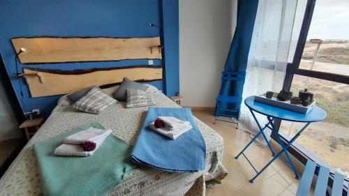 阿布里斯Los Abrigos Ocean relax, wifi, playas的一间卧室配有一张带两个枕头和一张桌子的床。