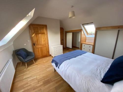 基尔拉什Beechwood View的一间卧室配有一张大床和一把椅子