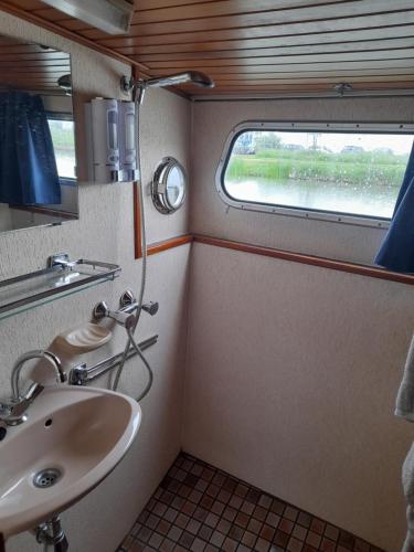 讷韦尔Une nuit sur l'eau à bord de l'IDEAAL的一间带水槽的浴室和火车上的窗户