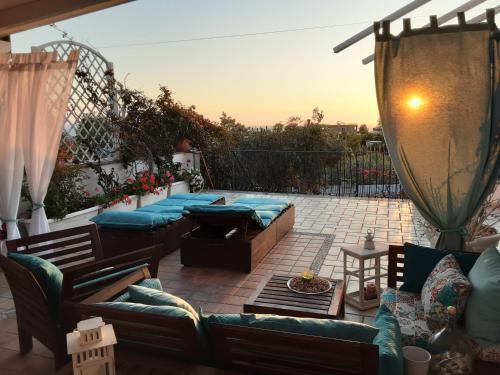巴科利DOMUS PARVA - Villa con bio-piscina, spa privata e appartamenti panoramici的一个带几张沙发和一张桌子的庭院