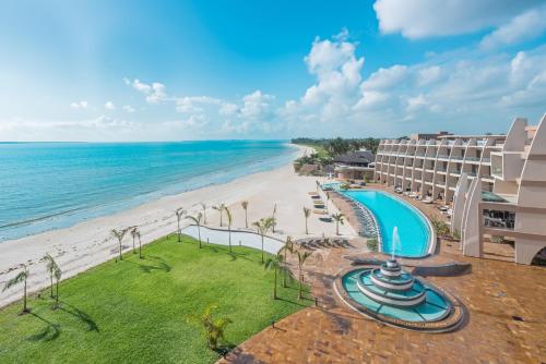 达累斯萨拉姆Ramada Resort By Wyndham Dar es Salaam的享有酒店和海滩的空中景致