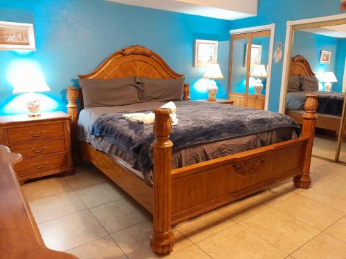 Greenacres CitySusan and Ledif's Tropical Hideaway的一间卧室配有木床和镜子