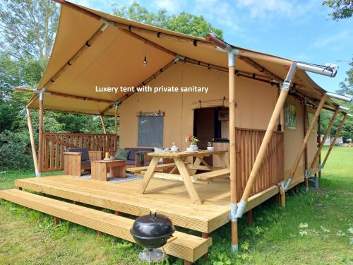 阿赫特克克Glamping Essenhof的一个带桌子和烤架的大帐篷