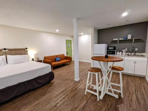 DunlapThe Honey Bee Motel的一间卧室配有一张床铺和一张桌子,还设有一间厨房