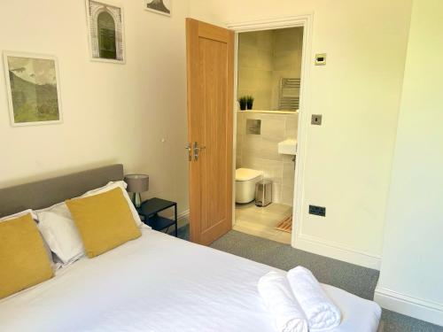 Forest HillStunning 2 Bed 2 Bath Luxury London Apartment!的一间带白色床的卧室和一间浴室
