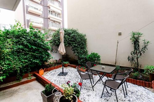 亚历山德鲁波利斯Hermes Modern Apartment的庭院配有桌椅和遮阳伞。