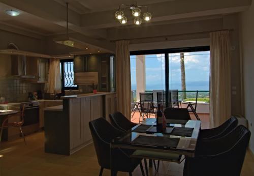 Markópoulon OropoúAmazing Villa with private pool的厨房和带桌子的客厅,享有海景