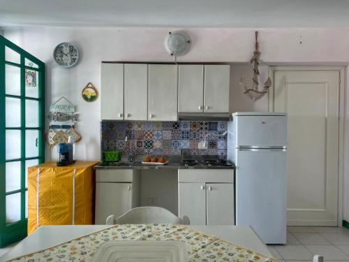 恩佩多克莱港LA TERRAZZA SUL MARE的厨房配有白色橱柜和白色冰箱。