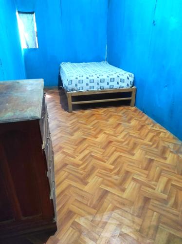 普卡尔帕EL REENCUENTRO的客房设有两张床,铺有木地板。