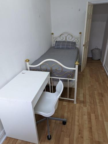 奥尔德姆Oldham town centre rm03的一间卧室配有一张床、一张桌子和一把椅子