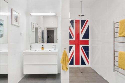 阿德莱德Azami - Charming Gilbert Cottage的浴室配有水槽和墙上的旗帜