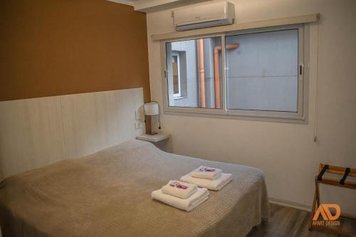 TartagalApart Design的卧室配有带2条毛巾的窗户,位于床上