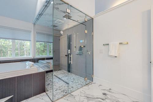 RumfordWebb River House的一间带玻璃淋浴和浴缸的浴室