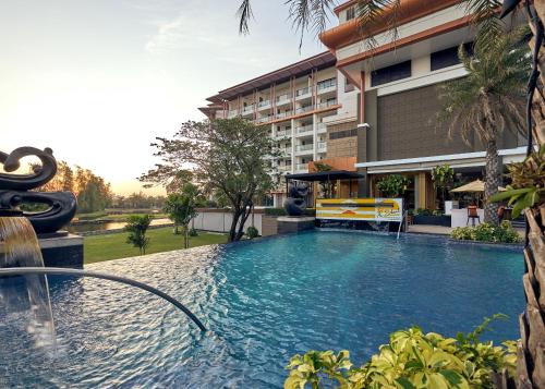 曼谷曼谷素万那普艾美高尔夫水疗度假酒店的大楼前的游泳池