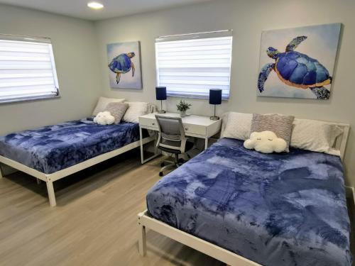 萨拉索塔Luxury 3BD house, Siesta Key Beach的一间卧室配有两张床、一张桌子和一张书桌。