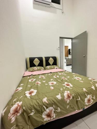 加央Aisy Guest House - MUSLlM Only的一间卧室配有一张带绿毯和粉红色鲜花的床