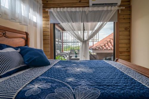 La EstrellaLoft con terraza en Santo Domingo的一间卧室配有一张带蓝色棉被的床和窗户。